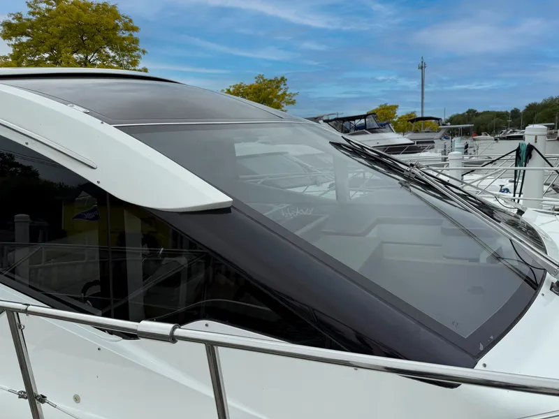 Slide: The Image of 2018 Galeon 560 Sky yacht with sleek design, docked at marina under blue sky. - 8