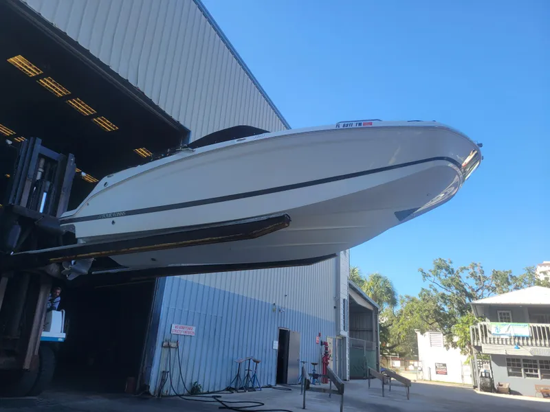 Slide: The Image of 2022 Four Winns HD3 boat being lifted outside a warehouse. - 1