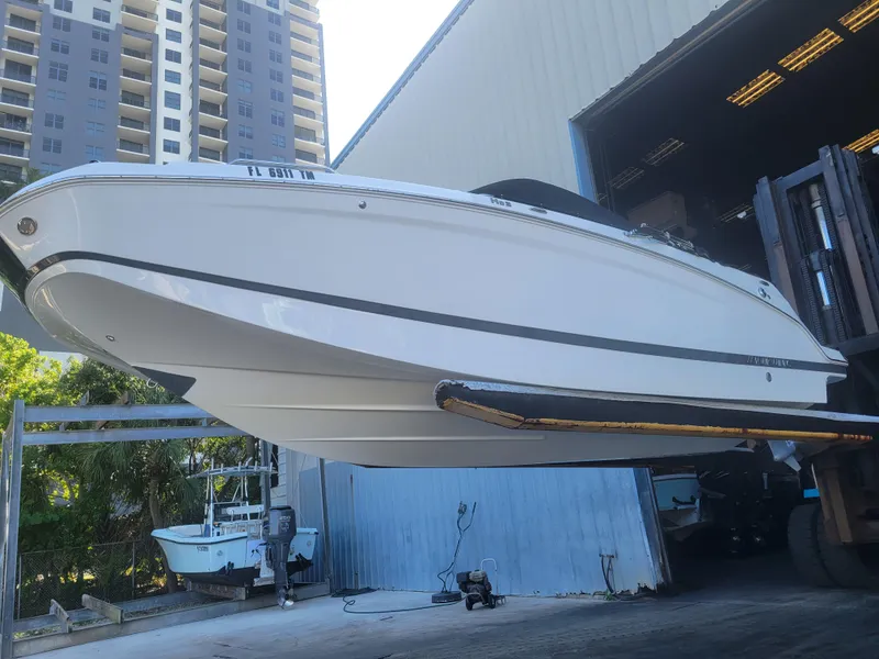 Slide: The Image of 2022 Four Winns HD3 boat in storage facility, elevated by forklift. - 2