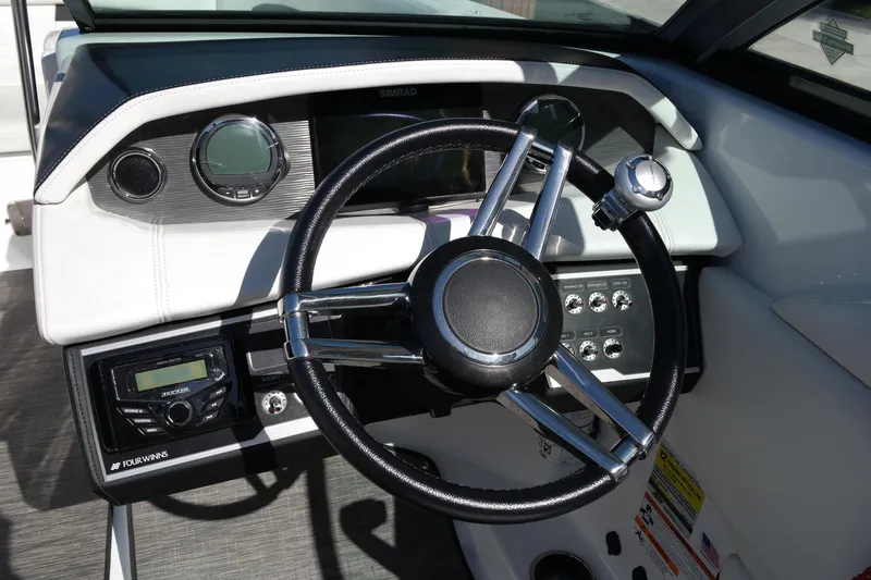 Slide: The Image of 2022 Four Winns HD3 boat dashboard with steering wheel and control panel. - 21