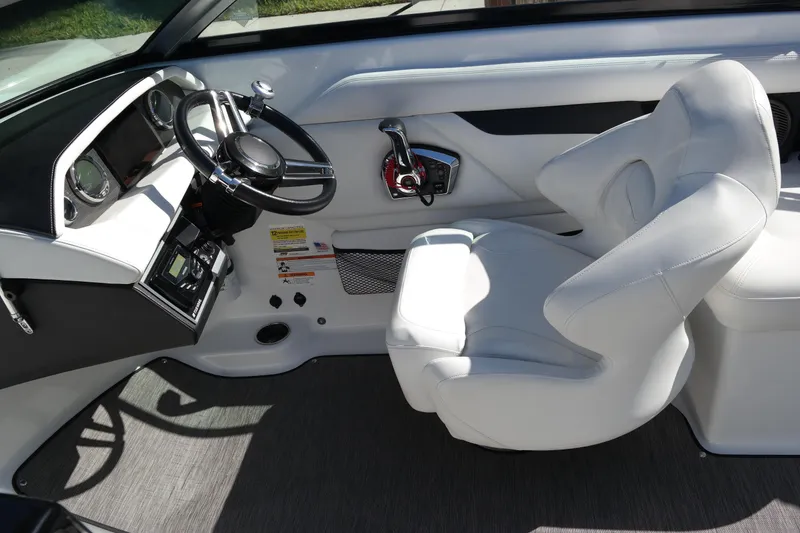 Slide: The Image of 2022 Four Winns HD3 boat interior with white captain's chair and steering wheel. - 23