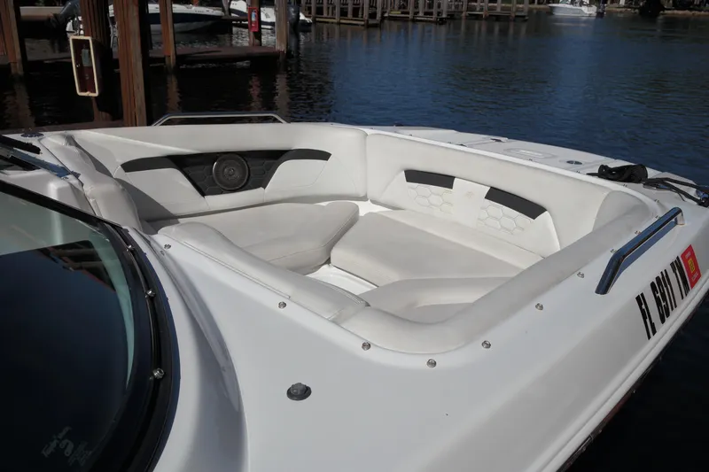 Slide: The Image of 2022 Four Winns HD3 boat with white seating, docked by the water. - 26
