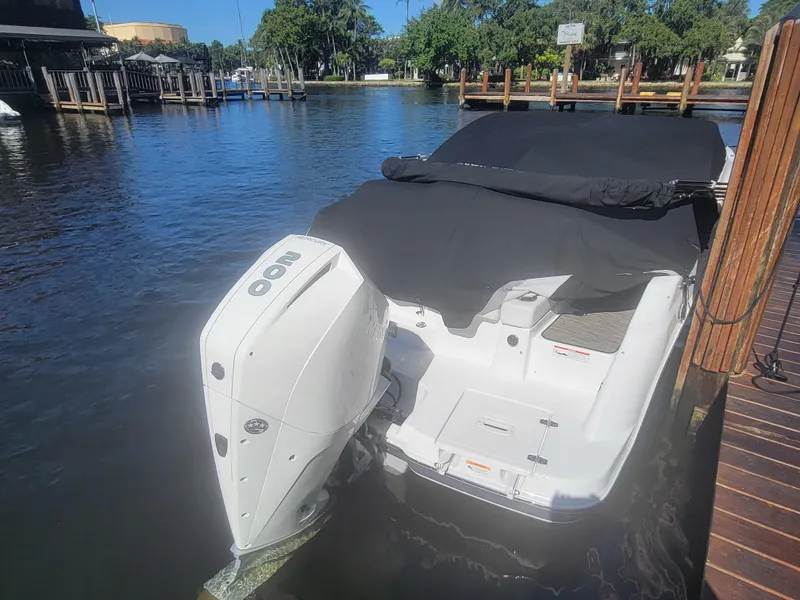 Slide: The Image of 2022 Four Winns HD3 boat docked with cover, featuring outboard motor. - 5