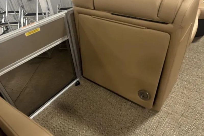 Slide: The Image of 2025 Barletta C22QC interior with tan seating and storage compartment. - 11