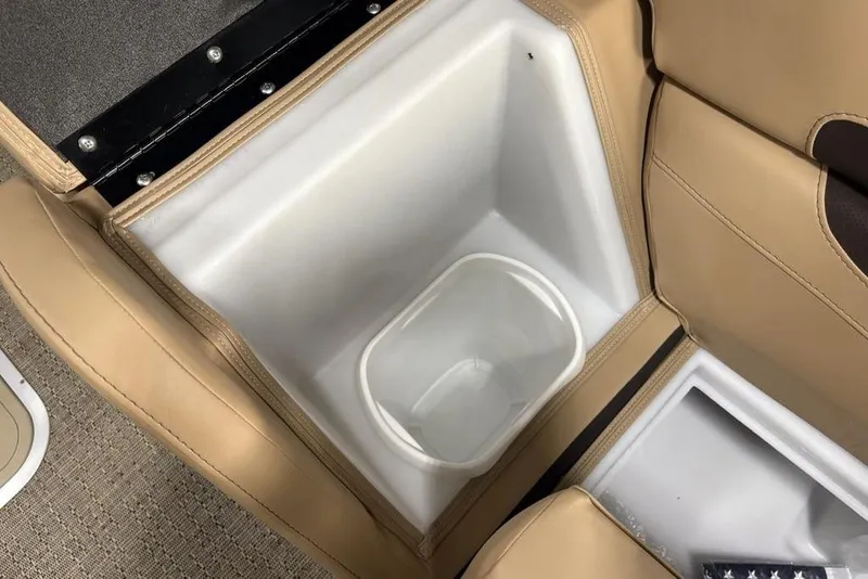 Slide: The Image of 2025 Barletta C22QC boat interior with beige seating and built-in storage compartment. - 13