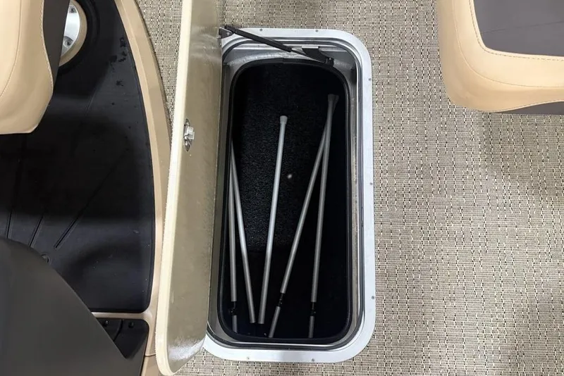 Slide: The Image of Open storage compartment in 2025 Barletta C22QC boat, revealing metal poles inside. - 15