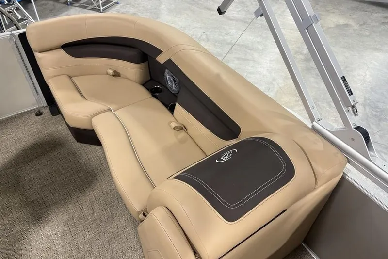 Slide: The Image of 2025 Barletta C22QC boat interior with beige and brown seating, featuring cup holders and speaker. - 19