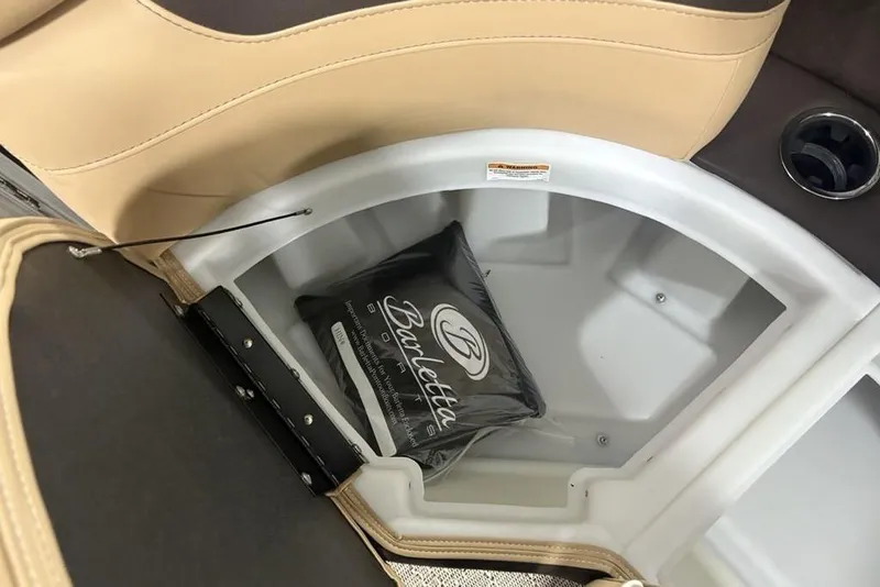 Slide: The Image of 2025 Barletta C22QC boat storage compartment with branded cushion and cup holder. - 23
