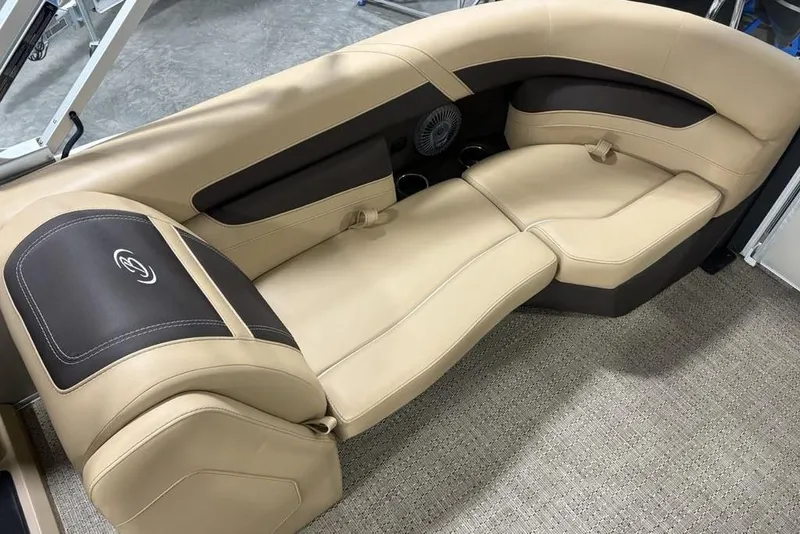 Slide: The Image of 2025 Barletta C22QC boat interior with beige and brown seating, cup holders, and speaker. - 28