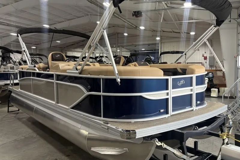Slide: The Image of 2025 Barletta C22QC pontoon boat with blue and beige design in showroom. - 36