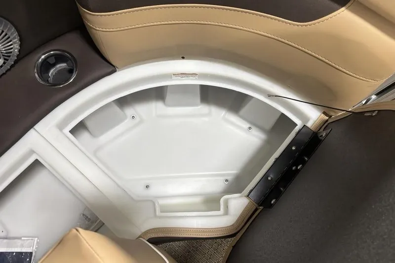Slide: The Image of 2025 Barletta C22QC boat interior storage compartment with cup holder and beige seating. - 4