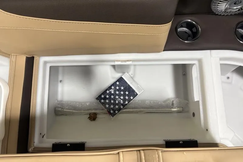 Slide: The Image of 2025 Barletta C22QC storage compartment with American flag and cup holders. - 7