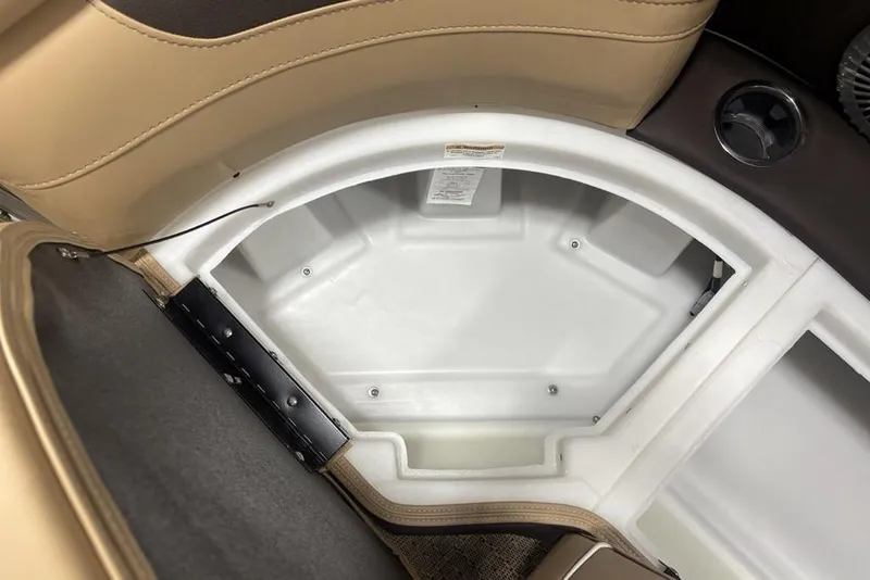 Slide: The Image of 2025 Barletta C22QC boat storage compartment with beige seating and cup holder. - 8