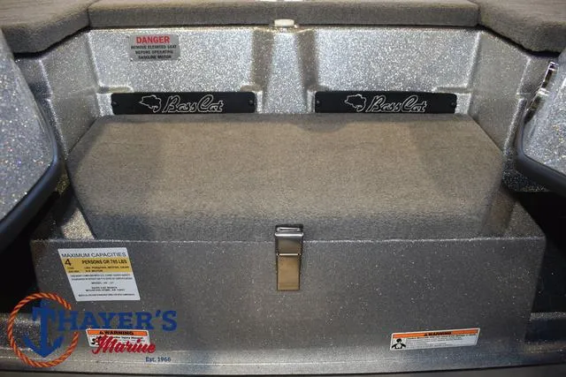 Slide: The Image of 2023 Bass Cat Puma STS boat storage compartment with safety labels and Thayer's Marine logo. - 18