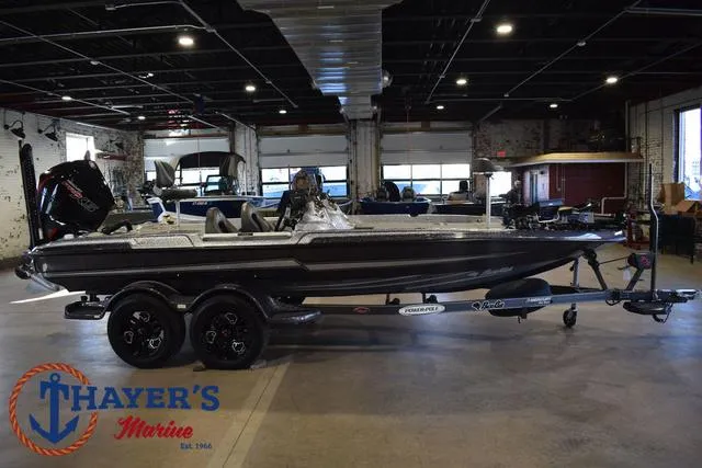 Slide: The Image of 2023 Bass Cat Puma STS boat displayed indoors at Thayer's Marine showroom. - 2
