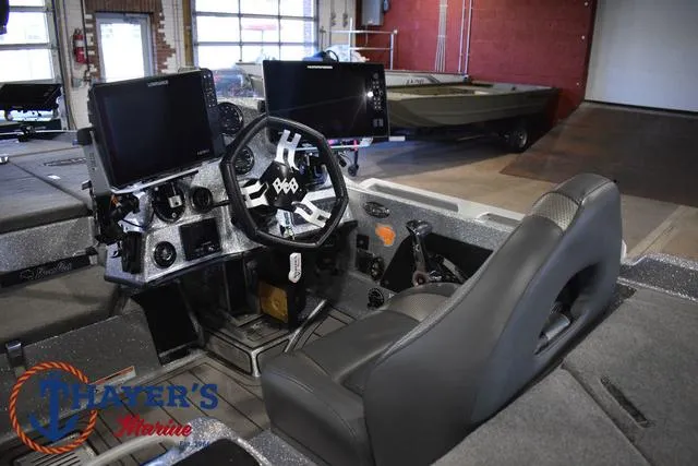 Slide: The Image of 2023 Bass Cat Puma STS boat interior with advanced navigation system and steering wheel. - 23