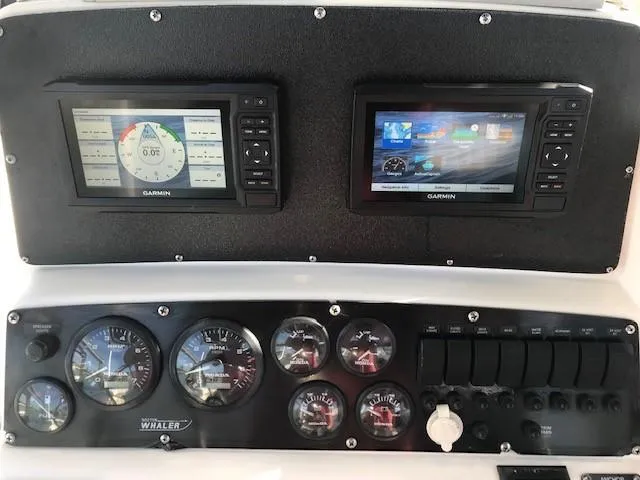 Slide: The Image of 1998 Boston Whaler 260 Outrage dashboard with Garmin displays and gauges. - 11