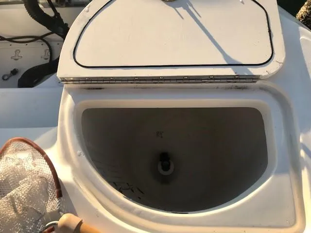 Slide: The Image of Boston Whaler 260 Outrage 1998 boat compartment with open lid and fishing net. - 17