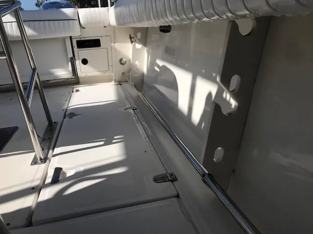 Slide: The Image of 1998 Boston Whaler 260 Outrage boat interior with white seating and metal railings. - 24