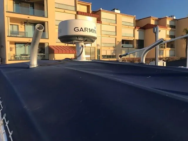 Slide: The Image of 1998 Boston Whaler 260 Outrage with Garmin radar, docked near modern buildings. - 32