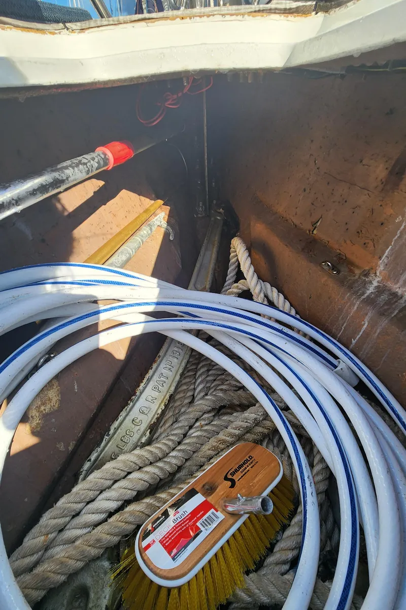 Slide: The Image of Storage compartment of 1983 Nautor Swan 651 with ropes, hose, and cleaning brush. - 16