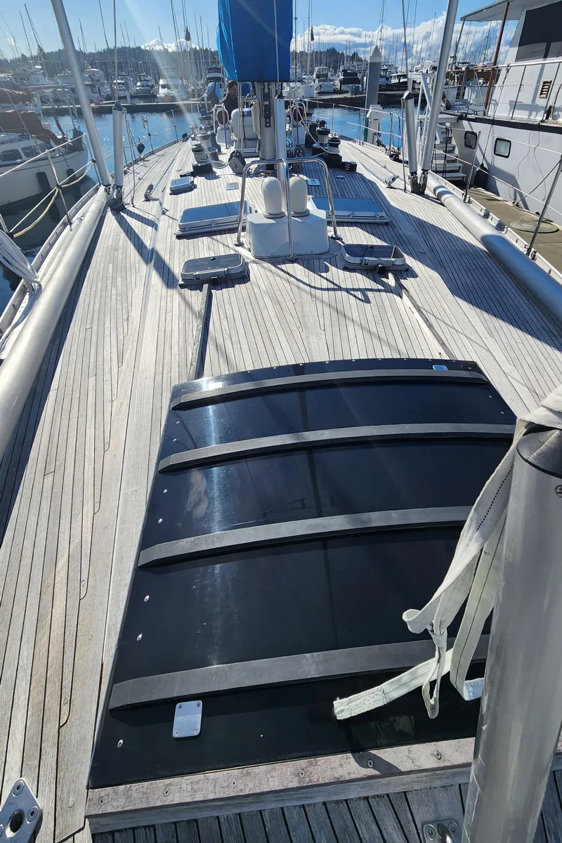 Slide: The Image of 1983 Nautor Swan 651 yacht deck with wooden finish, docked at a marina. - 20