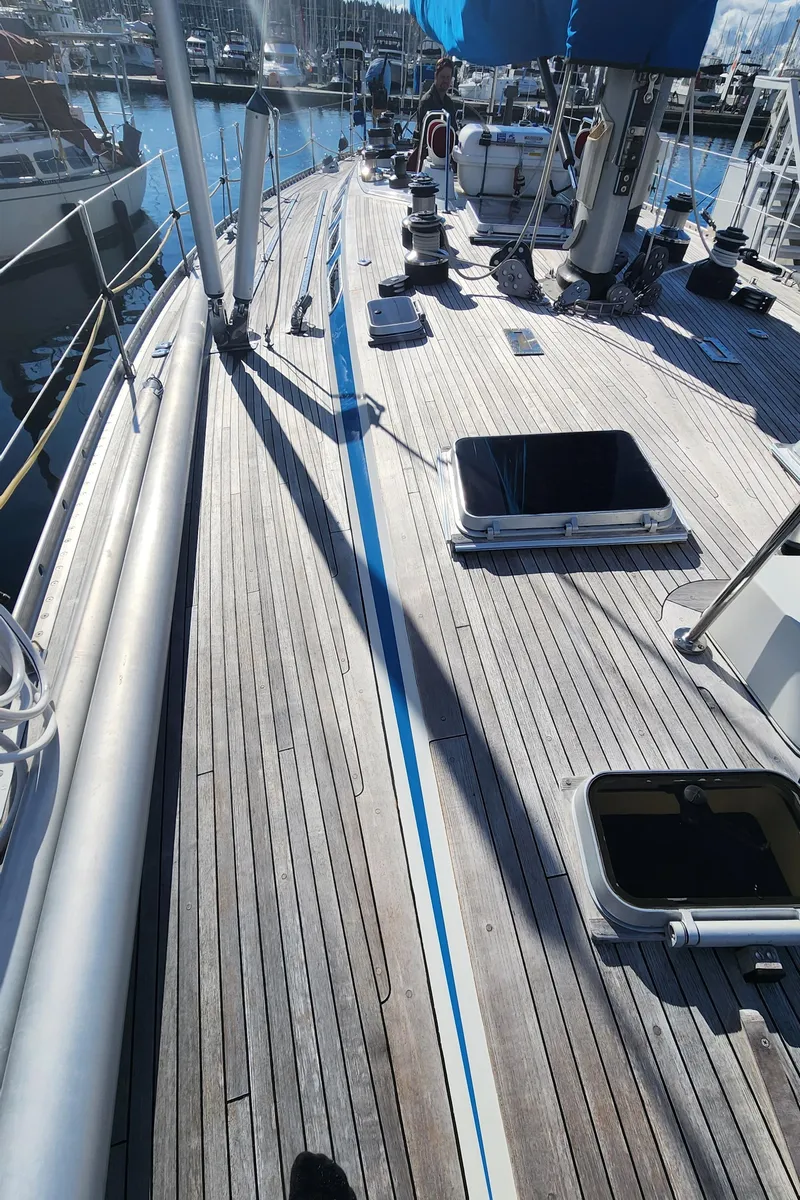 Slide: The Image of 1983 Nautor Swan 651 yacht deck with open hatches in a marina setting. - 21