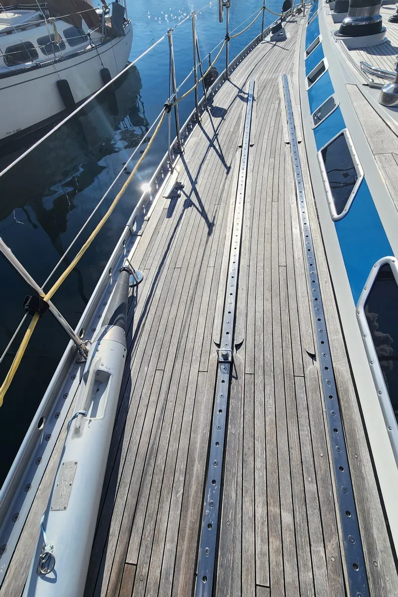 Slide: The Image of Deck of 1983 Nautor Swan 651 yacht with wooden finish and metal railings. - 22
