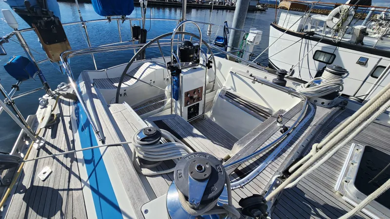 Slide: The Image of Cockpit of 1983 Nautor Swan 651 yacht with steering wheel and winches, docked at marina. - 23