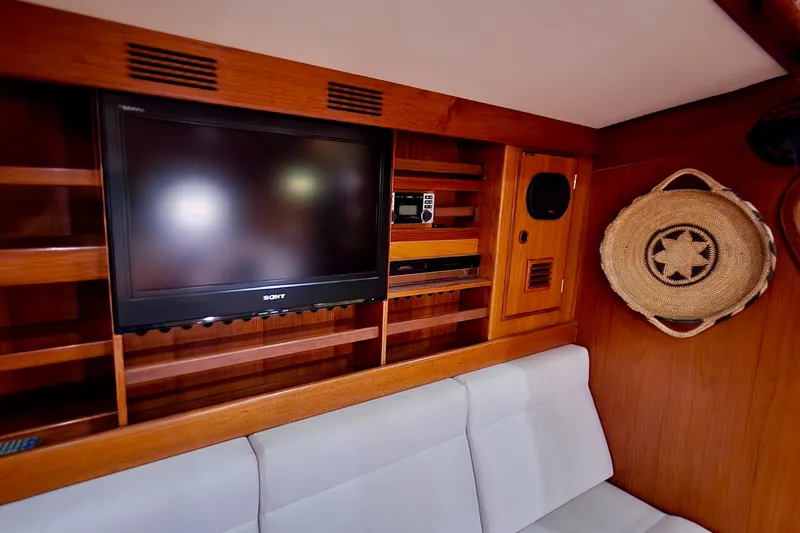 Slide: The Image of Interior of 1983 Nautor Swan 651 yacht with TV, shelving, and decorative basket. - 29