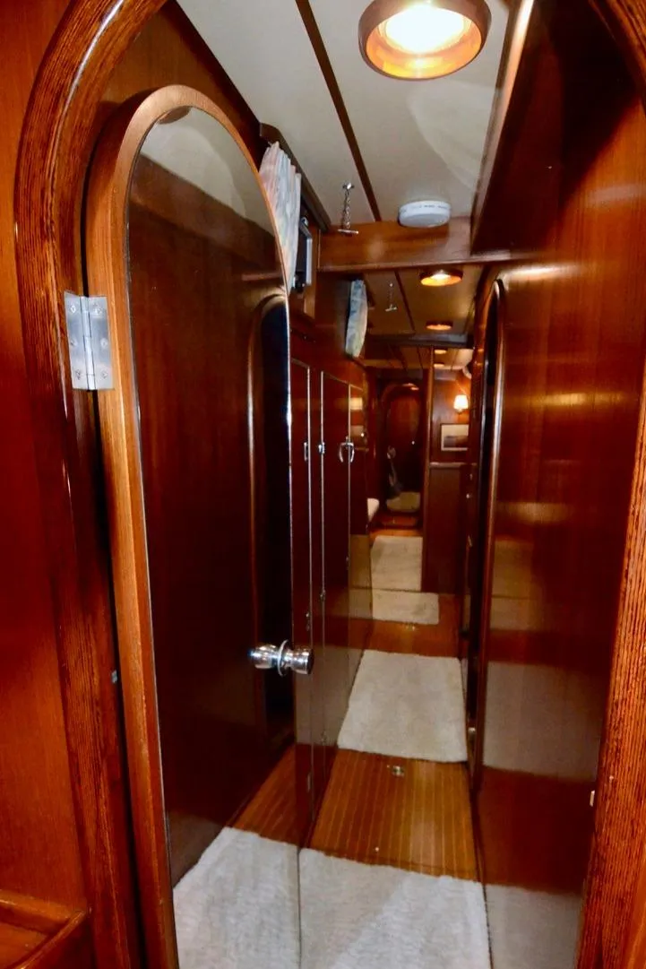 Slide: The Image of Interior hallway of 1983 Nautor Swan 651 yacht with wooden finishes and soft lighting. - 32