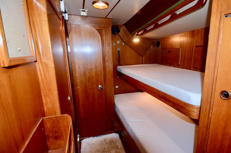 Slide: The Image of Interior of 1983 Nautor Swan 651 yacht with wooden bunk beds and cozy lighting. - 38