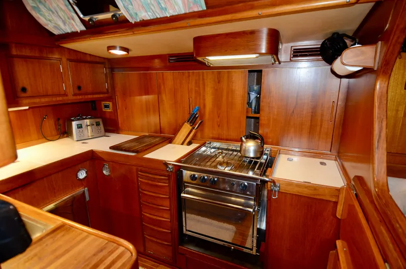 Slide: The Image of Galley kitchen in 1983 Nautor Swan 651 yacht with wooden cabinetry and stainless steel stove. - 40