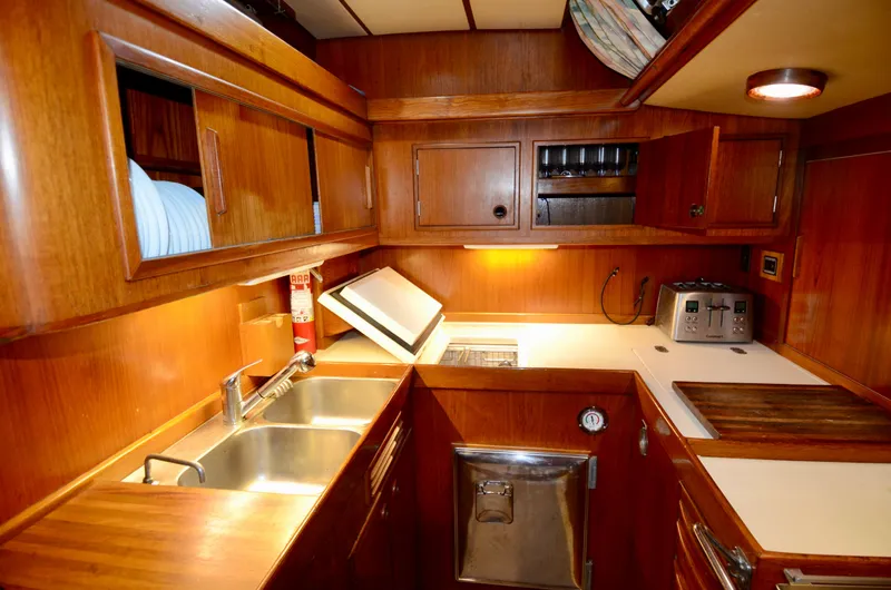 Slide: The Image of 1983 Nautor Swan 651 yacht kitchen with wooden cabinetry and modern appliances. - 41