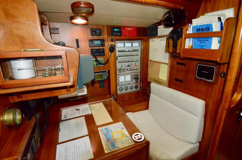 Slide: The Image of Navigation station of 1983 Nautor Swan 651 yacht with control panels and seating. - 43