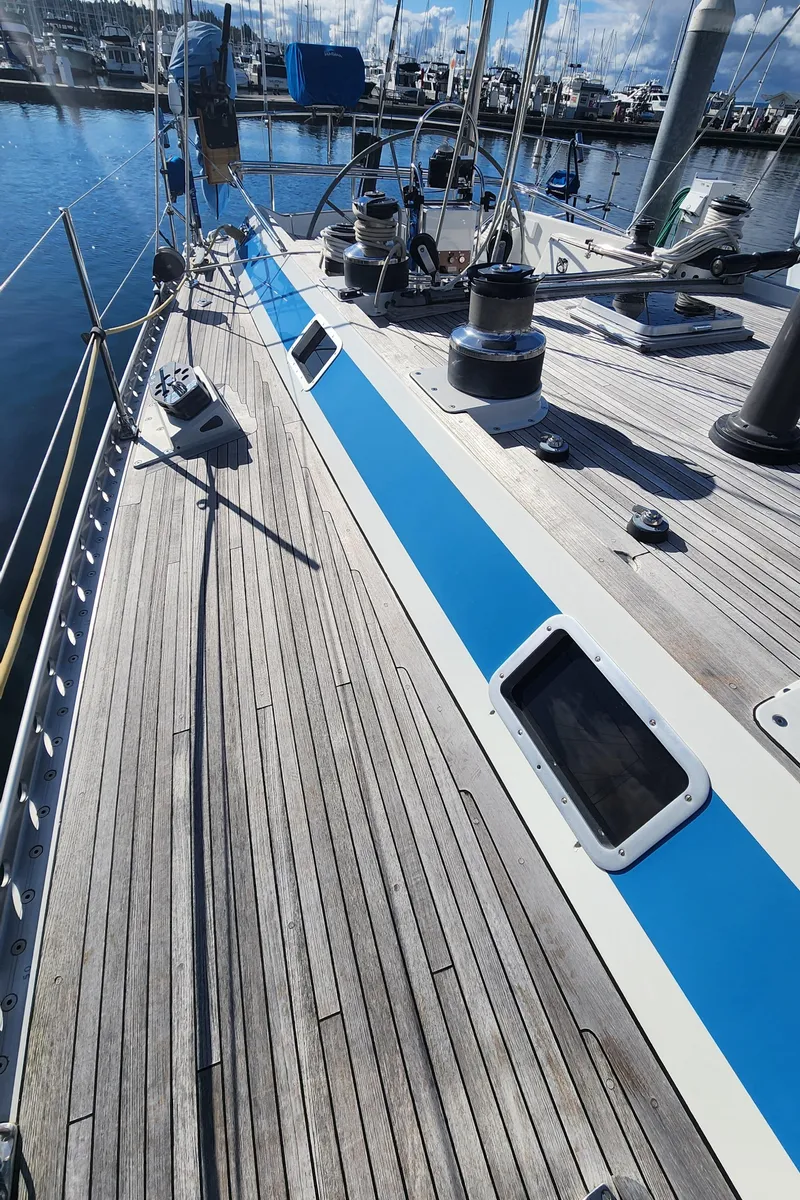 Slide: The Image of 1983 Nautor Swan 651 yacht deck with blue accents, docked in a marina. - 8