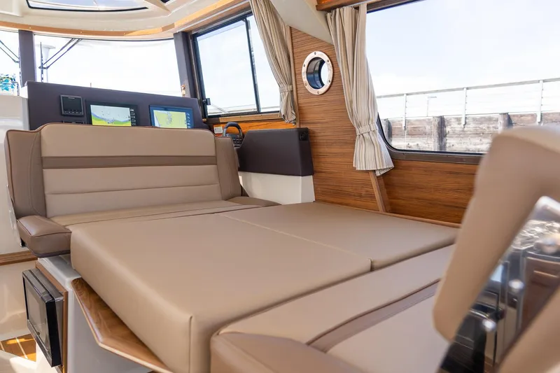 Slide: The Image of 2025 Ranger Tugs R-29 CB interior with convertible seating and modern navigation displays. - 9