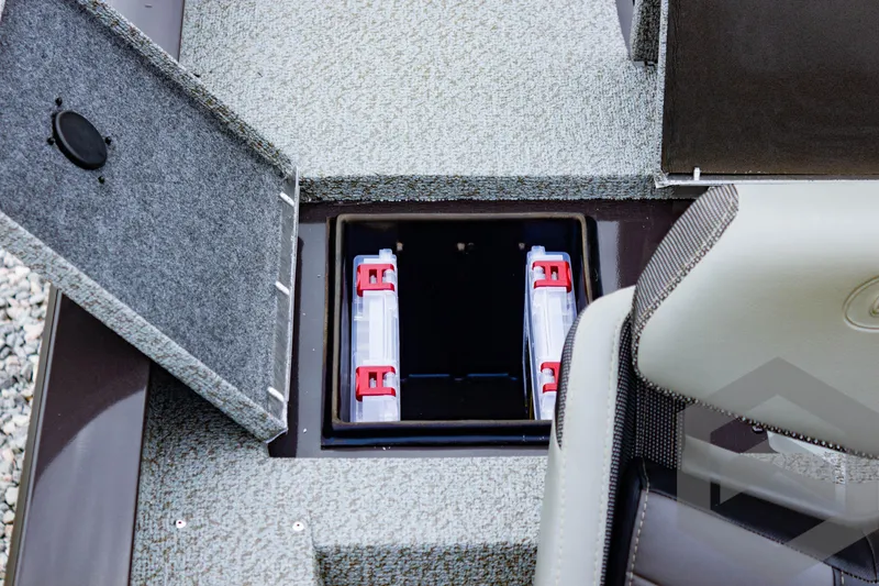 Slide: The Image of 2025 G3 Sportsman 1810 boat storage compartment with open hatch and visible battery holders. - 48