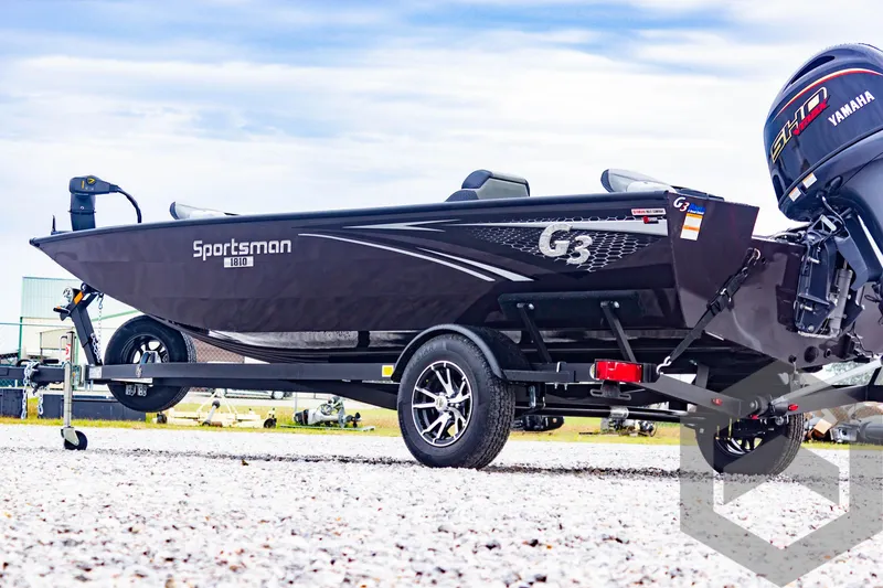Slide: The Image of 2025 G3 Sportsman 1810 boat with Yamaha motor on trailer, parked on gravel. - 7