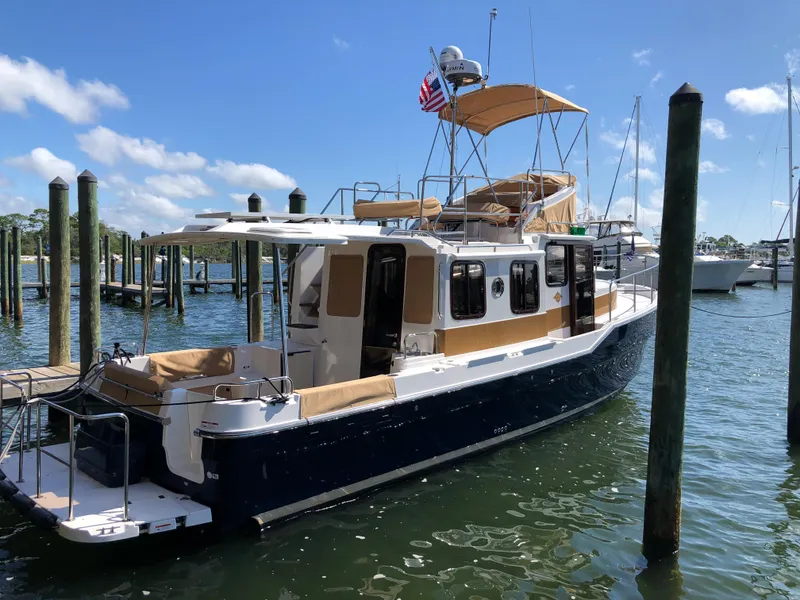 Slide: The Image of 2025 Ranger Tugs R-31 CB boat docked in sunny marina. - 1