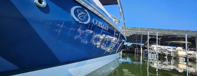 Slide: The Image of 2006 Cobalt 240 boat docked in marina, reflecting on calm water. - 13