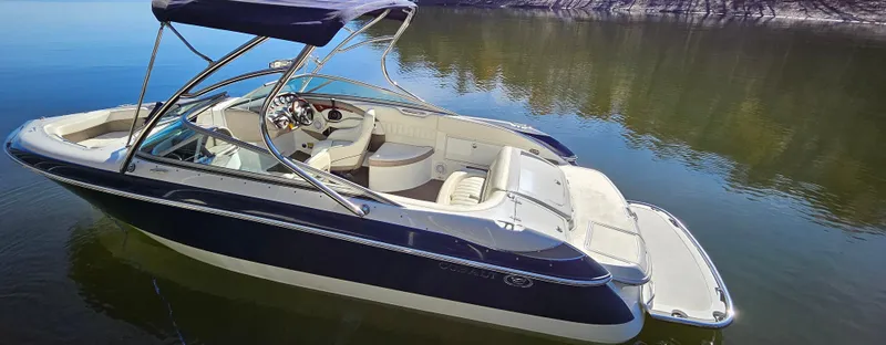 Slide: The Image of 2006 Cobalt 240 boat on calm water, featuring sleek design and spacious seating. - 14