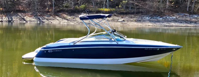 Slide: The Image of 2006 Cobalt 240 boat on calm lake with forested shoreline. - 3
