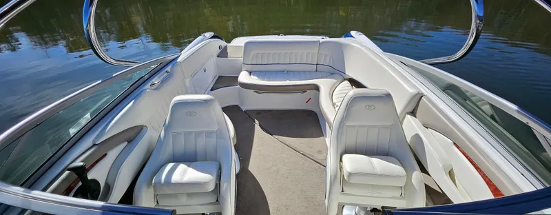 Slide: The Image of 2006 Cobalt 240 boat interior with white leather seating on calm water. - 4