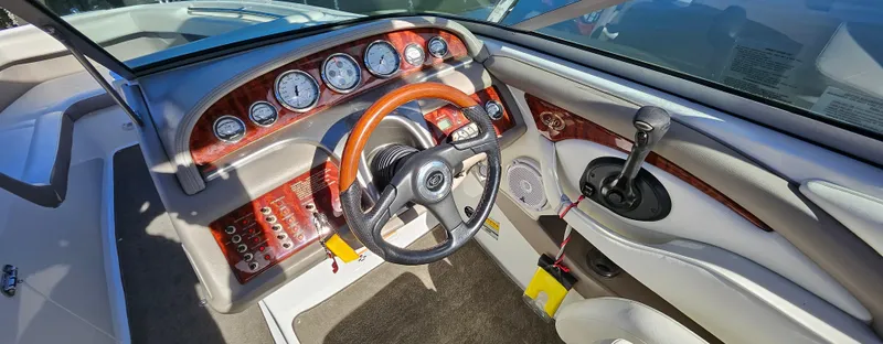 Slide: The Image of 2006 Cobalt 240 boat dashboard with wood accents and steering wheel. - 9