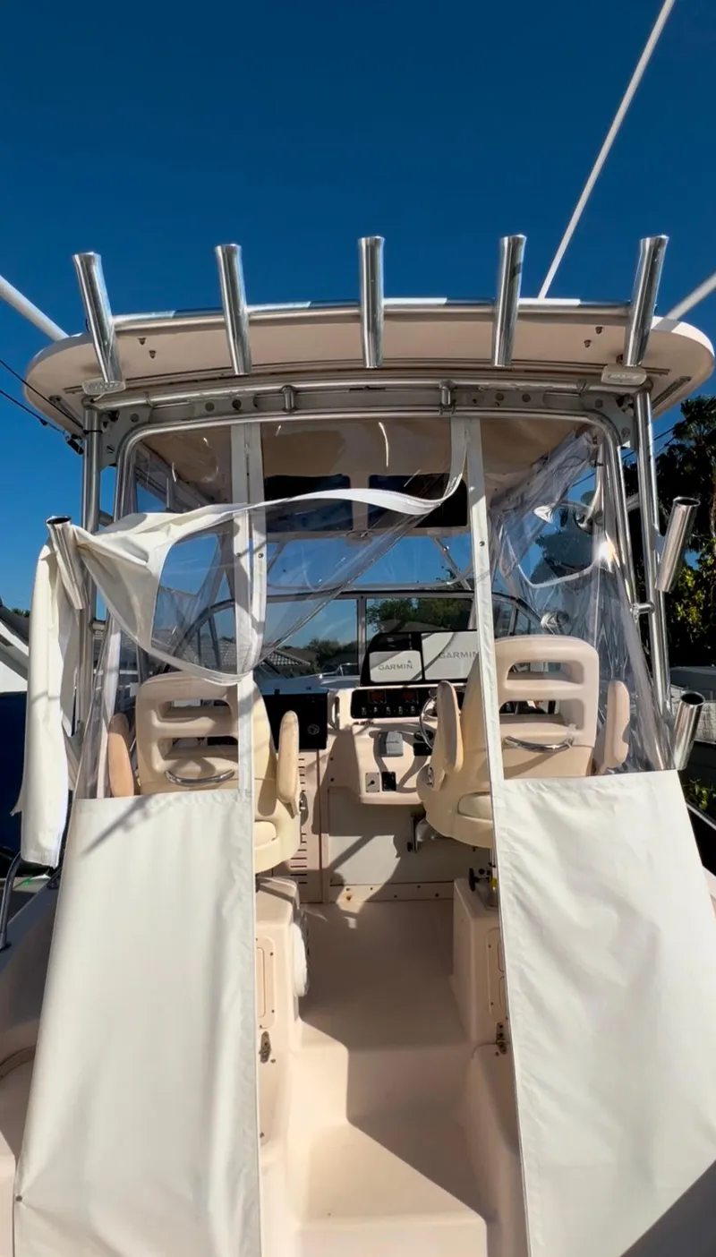 Slide: The Image of 2006 Grady-White 282 Sailfish boat cockpit with clear enclosure and seating. - 12