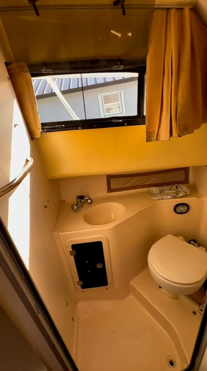 Slide: The Image of Compact bathroom in 2006 Grady-White 282 Sailfish boat with window and curtain. - 9