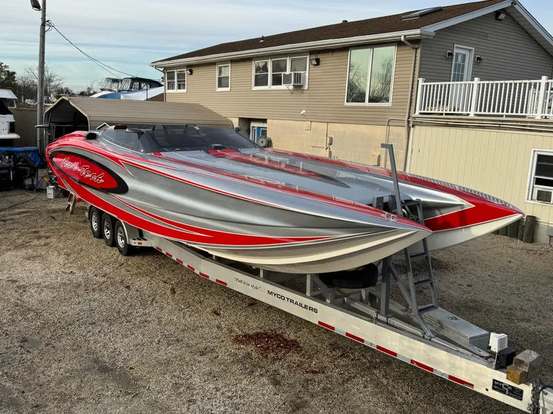 The Image of 2010 Nor-Tech 4000 Roadster powerboat on trailer, featuring sleek red and silver design. - 0