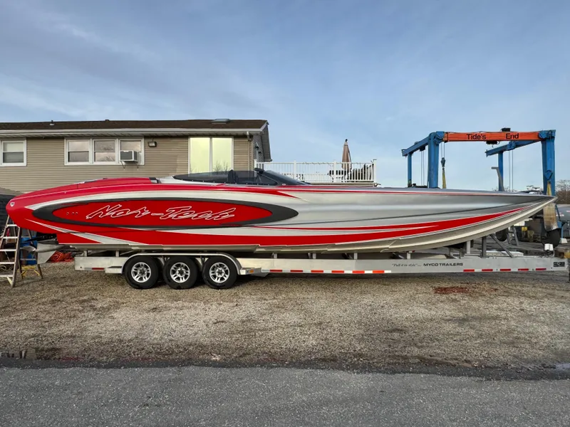 Slide: The Image of 2010 Nor-Tech 4000 Roadster boat on trailer, featuring sleek red and silver design. - 2