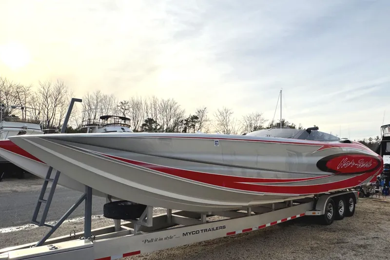 Slide: The Image of 2010 Nor-Tech 4000 Roadster boat on trailer, featuring sleek red and silver design. - 5